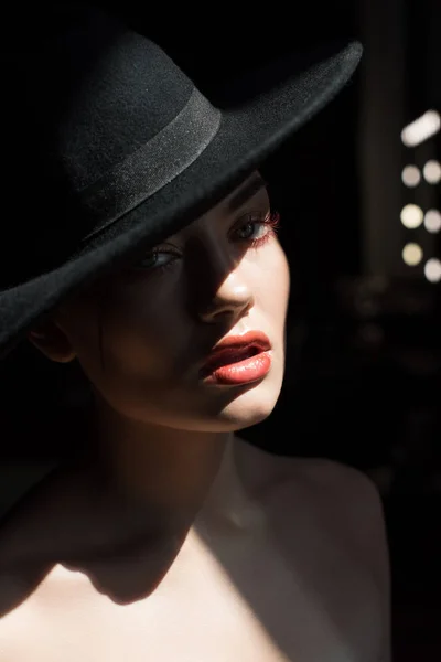 Belle fille avec maquillage posant en feutre noir chapeau — Photo de stock