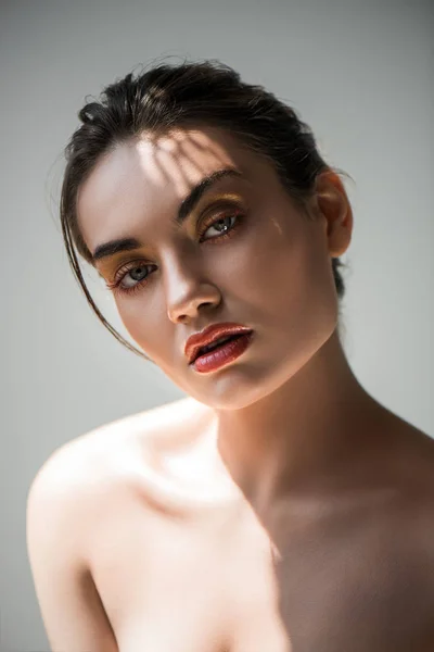 Attraktive, stylische junge Frau mit Make-up, isoliert auf grau — Stockfoto