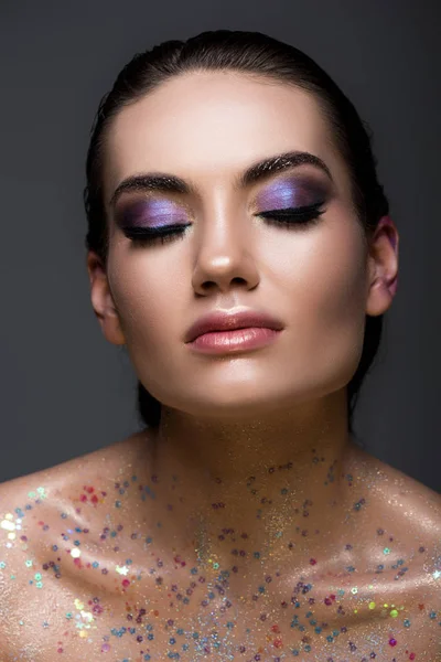 Attractive glamorous girl with closed eyes and glitter makeup, isolated on grey — Stock Photo