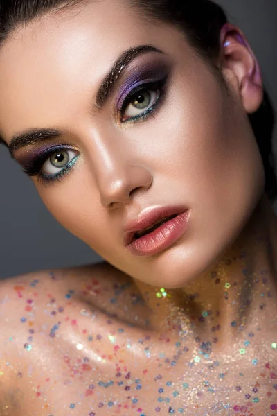 Alla moda ragazza glamour in posa con glitter sul corpo, isolato su grigio — Foto stock