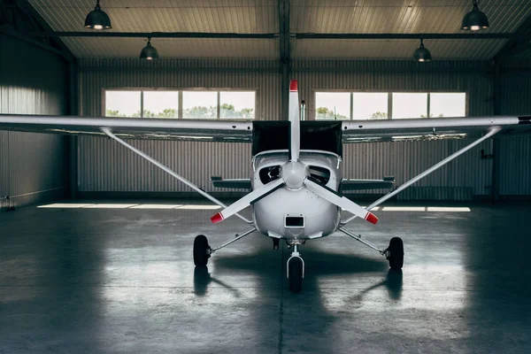 Pequeno avião moderno em pé no hangar — Fotografia de Stock