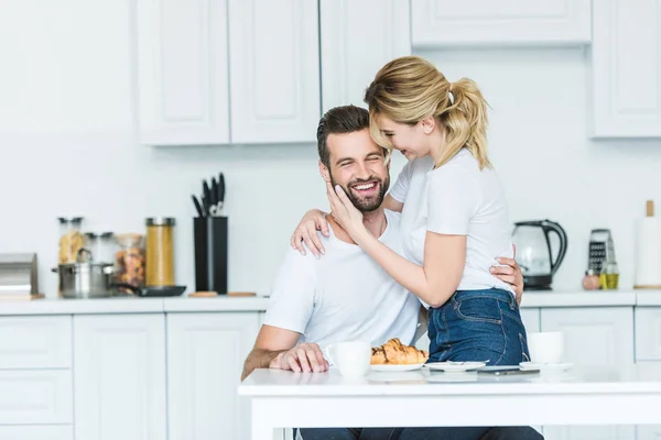 Attraktives lächelndes Mädchen umarmt glücklichen Freund beim gemeinsamen Frühstück — Stockfoto