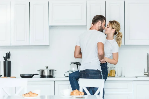 Belo jovem casal apaixonado beijando na cozinha de manhã — Fotografia de Stock