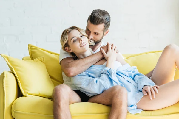 Beau jeune homme en sous-vêtements étreignant jolie petite amie à la maison — Photo de stock