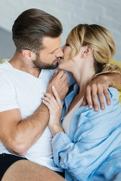 Beautiful passionate young couple in love kissing at home — Stock Photo