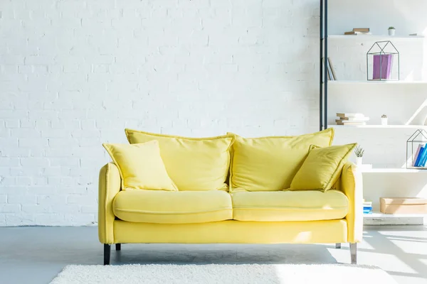 Cozy yellow sofa with cushions in living room interior — Stock Photo