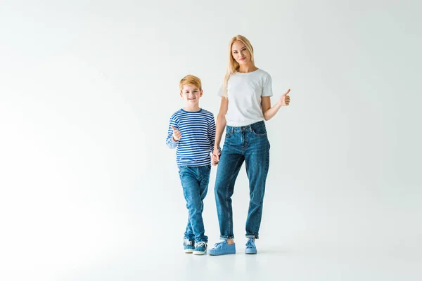 Cheerful mother and son holding hands and showing thumbs up on white — Stock Photo