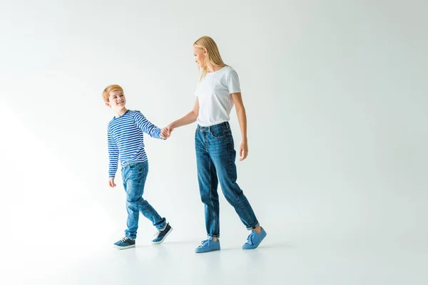 Mother and son holding hands and looking at each other on white — Stock Photo