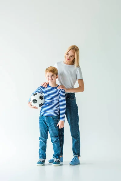 Mother and son standing with football ball on white — Stock Photo