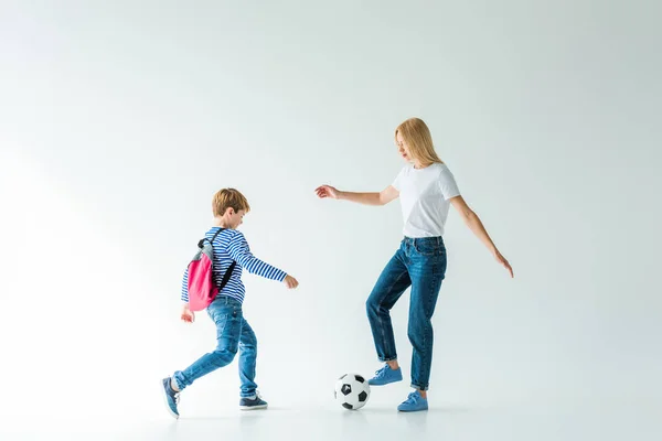 Mutter und Sohn mit Rucksack spielen Fußball auf Weiß — Stockfoto