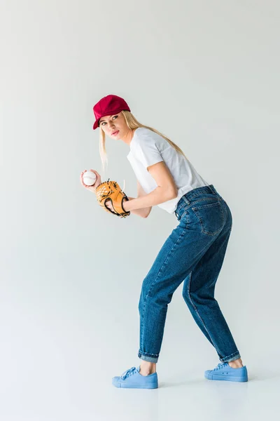 Attraente lanciatore di baseball in berretto rosso con guanto da baseball e palla isolata su bianco — Foto stock