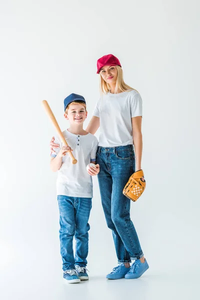 Mother and son looking at camera and holding baseball bat, glove and ball on white — Stock Photo