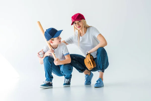 Mamãe e filho agachamento com bastão de beisebol e luva no branco — Fotografia de Stock