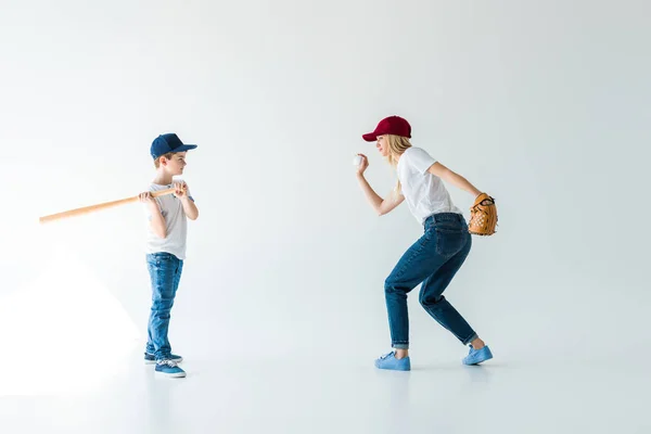 Vue latérale de maman lançant balle de baseball au fils avec chauve-souris isolée sur blanc — Photo de stock