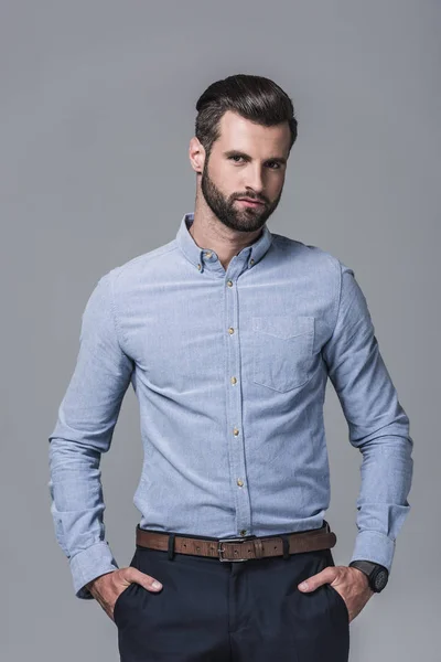 Елегантний стильний бізнесмен позує в офіційному одязі, ізольований на сірому — стокове фото