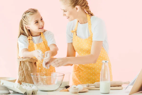 Attrayant jeune mère enseignant fille comment pétrir la pâte isolée sur rose — Photo de stock