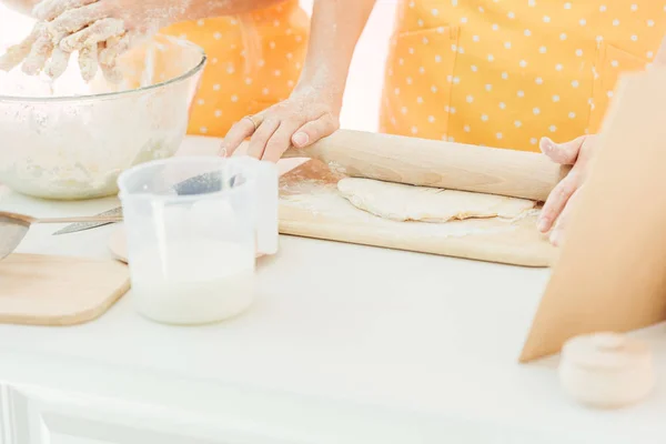 Plan recadré de mère et fille pétrissant la pâte ensemble isolé sur rose — Photo de stock