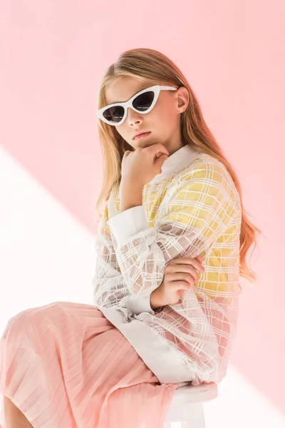 Adorable fashionable youngster in trendy sunglasses posing on pink — Stock Photo