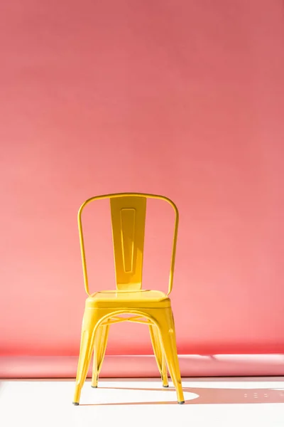 Estúdio tiro da cadeira amarela na moda e no rosa — Fotografia de Stock