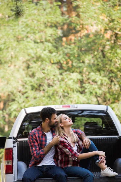 Couple assis ensemble sur une camionnette dans la forêt — Photo de stock
