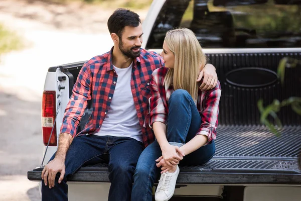 Junges Paar umarmt sich auf Pickup-Truck und schaut einander an — Stockfoto