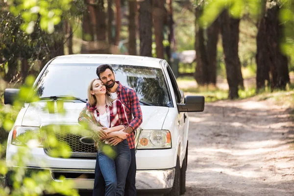 Jovem casal abraçando perto pickup caminhão na floresta — Fotografia de Stock