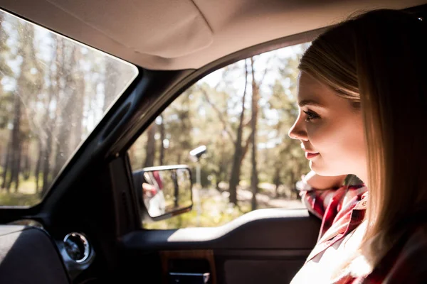 Bela motorista do sexo feminino sentado no carro na floresta — Fotografia de Stock