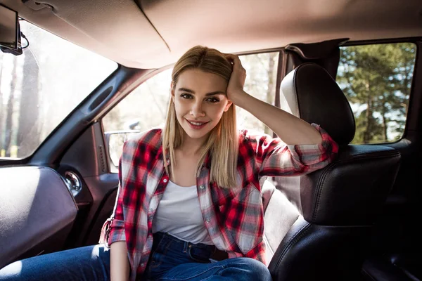 Hermosa sonriente hembra conductor sentado dentro de coche - foto de stock