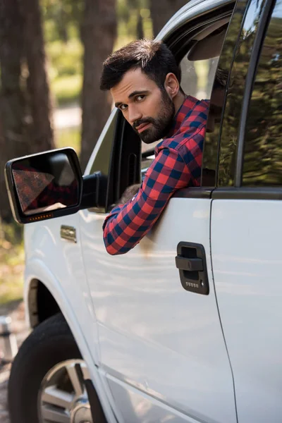 Bearded driver in white pickup truck looking at camera — Stock Photo