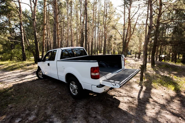 White pickup car with opened truck in forest — Stock Photo