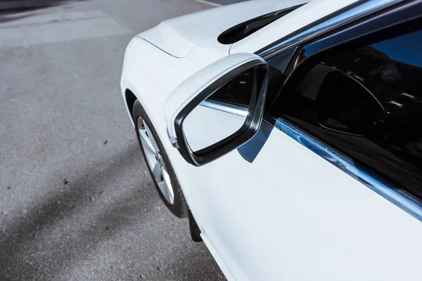 Side mirror and wheel of new white car on street — Stock Photo