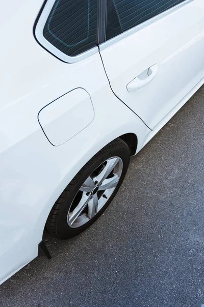 Cropped image of wheel and door of new white car on street — Stock Photo