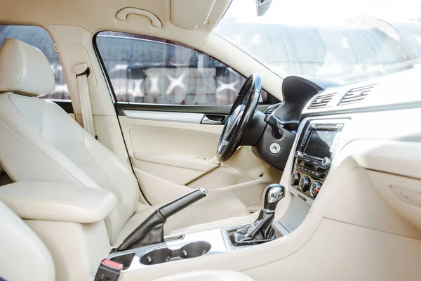 Immagine ritagliata del volante e sedili in pelle nuova auto sulla strada — Foto stock