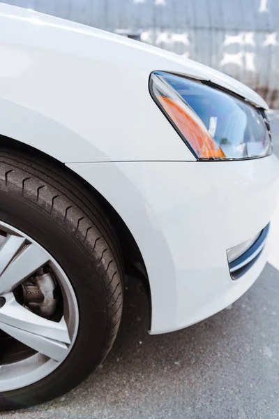 Cropped image of new car headlight and wheel — Stock Photo