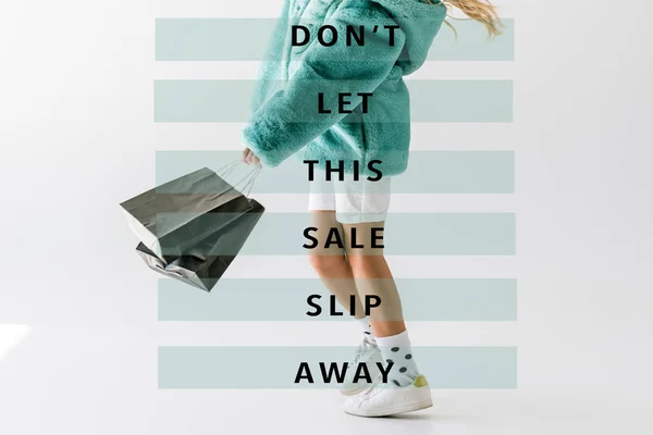 Cropped view of girl in turquoise fur coat holding black shopping bags on white, dont let this sale slip away inscription — Stock Photo