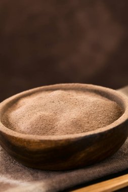 Ahşap kase kakao veya çikolata içecek tozu, doğal ışık ile fotoğraflandı, üst (Seçici Odak, Odak çikolata tozu ortasından)