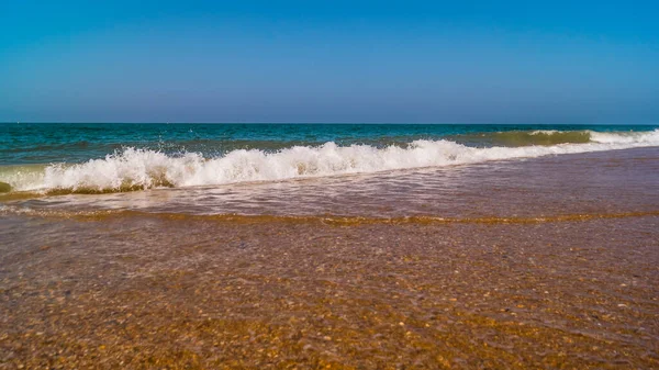 아름다운 조약돌 해변에 파도와 푸른 하늘 — 스톡 사진