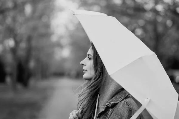 凍えるフードの傘の下に隠れての若い女性の画像 — ストック写真