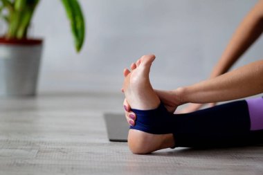 Oturma odasında yoga yapan kadının yakın çekimi