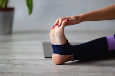 Oturma odasında yoga yapan kadının yakın çekimi