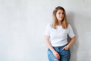Beyaz tişörtlü ve kot pantolonlu güzel bir kadın. 