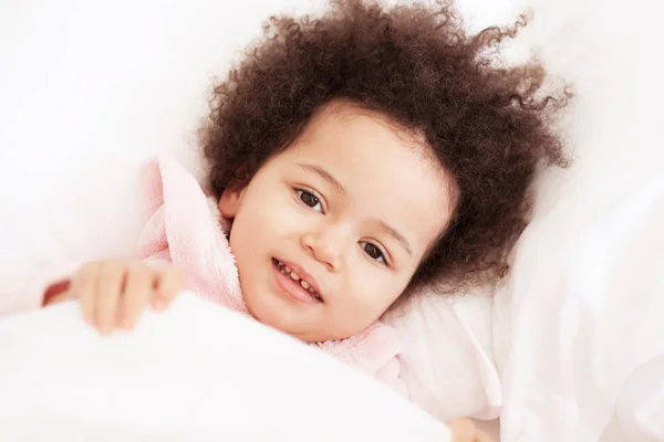 Schattig klein meisje liggend in gezellig bed — Stockfoto