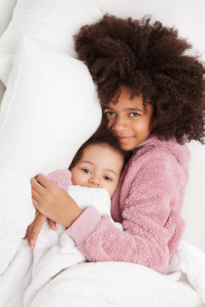 Two little sisters in bed 