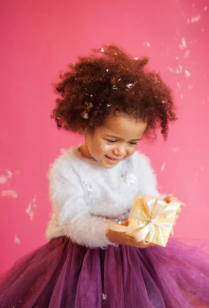 Schattig klein meisje met een glimmende geschenkdoos — Stockfoto