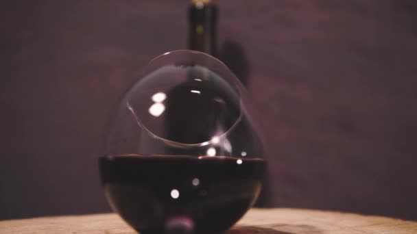 ラウンドでワインのガラスひびの入った木製のテーブル 360 美しい暗赤色背景 — ストック動画