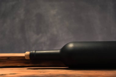 Siyah şişe kırmızı şarap yeni ve kırmızı ahşap bir masa üzerinde. Güzel arka plan