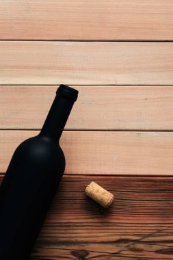 Siyah şişe kırmızı şarap yeni ve kırmızı ahşap bir masa üzerinde. Güzel arka plan