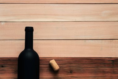 Siyah şişe kırmızı şarap yeni ve kırmızı ahşap bir masa üzerinde. Güzel arka plan