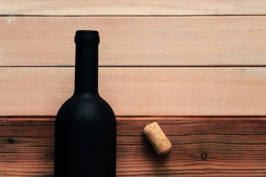 Siyah şişe kırmızı şarap yeni ve kırmızı ahşap bir masa üzerinde. Güzel arka plan