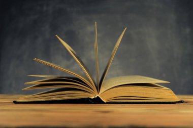 Eski meşe ahşap bir masa üzerine eski kitap. Güzel koyu arka plan.
